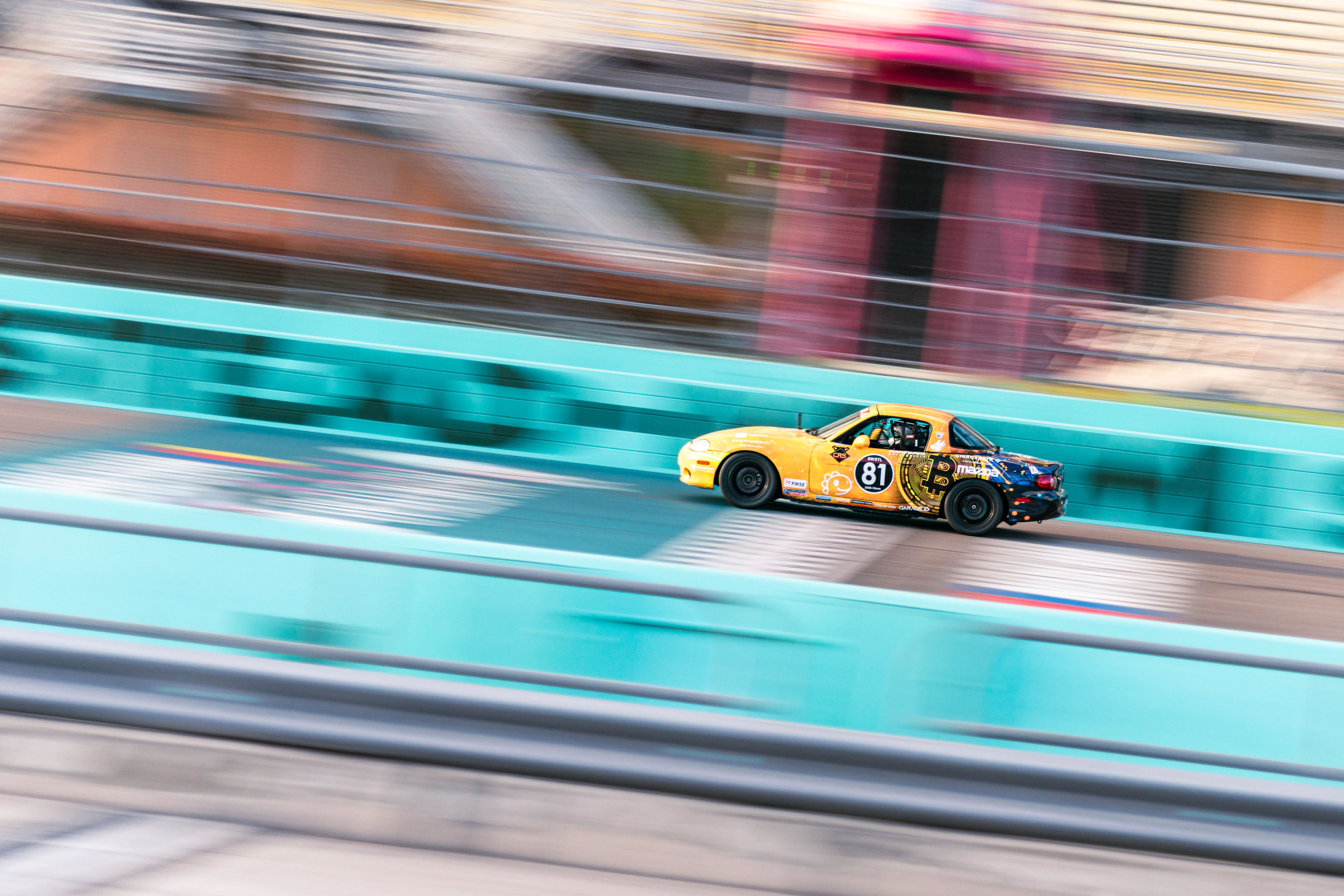 TOSHI #81 yellow Bitcoin Miata racing at high speed — Joseph Saddington pro spec miata driver
